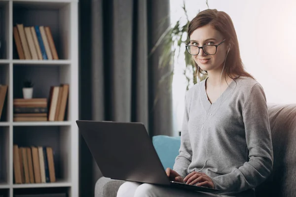 Charmig flicka i glasögon tillbringar fritid med laptop — Stockfoto