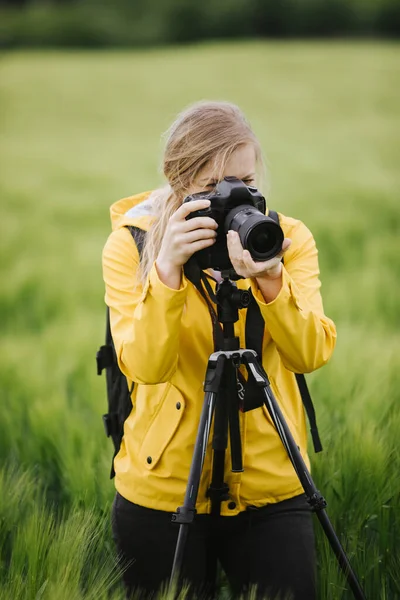 Woman taking pictures of green wheat field