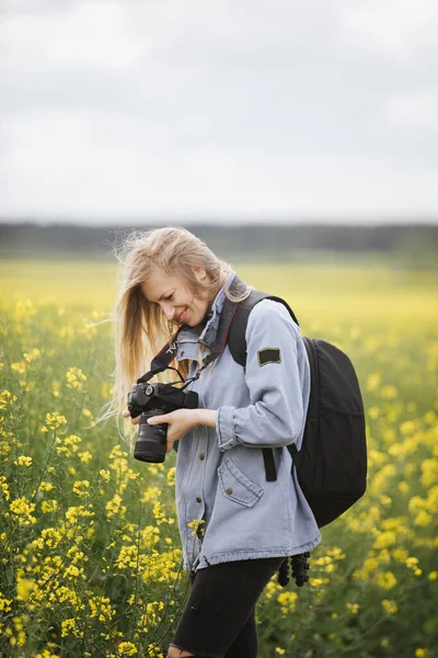 Glimlachende vrouw het bekijken van foto 's op camera buiten — Stockfoto