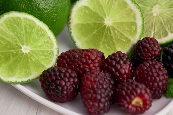 Blackberries and lemon slices on white ceramic cup