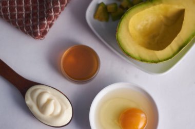 Avokado yumurtalı mayonez maskesi kaşık ve bal.
