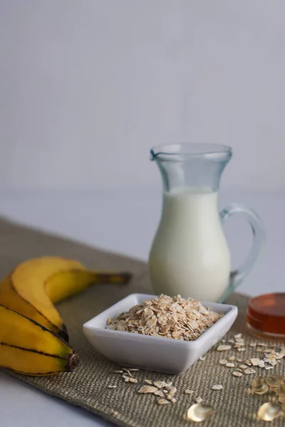 Yulaf lapası maskesi muz sütü bal ve vitamin için malzemeler.