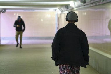 Pembe ışık altında geçiş yapan şık bir adam.