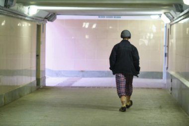 Pembe ışık altında geçiş yapan şık bir adam.