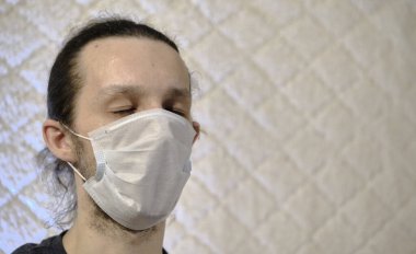 Beyaz arka plan koronavirüs renginde tıbbi maskeli bir adam.