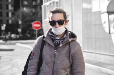 Tıbbi maskeli ve gözlüklü bir adam.