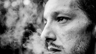 Adam sigara içiyor. Siyah beyaz yakın plan.