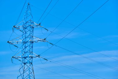 Mavi gökyüzüne karşı elektrik hatları