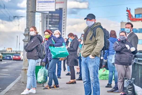 Coronavirus karantinası sırasında Moskova 'daki bir otobüs durağında maske takan bir sürü insan var.