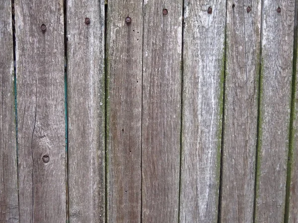 未処理の割れた垂直板で作られた古い木製の柵は — ストック写真