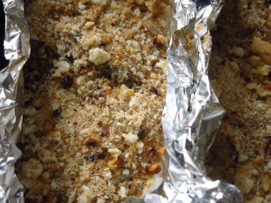 Balık ekmek kırıntıları içinde folyo içinde fırının önünde yemek tepsisi üzerinde sofrada, bayram yemeği.