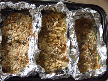 Balık ekmek kırıntıları içinde folyo içinde fırının önünde yemek tepsisi üzerinde sofrada, bayram yemeği.