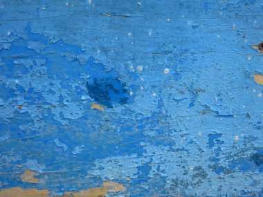 Parlak mavi boya eski kabuk soyma tahtasından soyuluyor