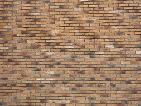 texture of beige or brown brick wall with colored bricks
