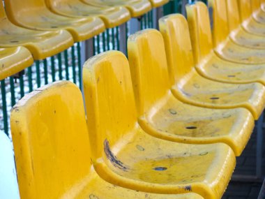 Sarı koltuklu bir futbol stadyumunun boş tribünleri