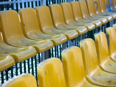 Sarı koltuklu bir futbol stadyumunun boş tribünleri