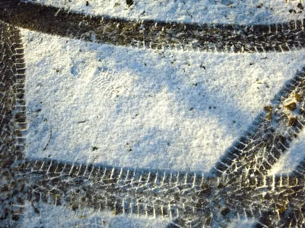 白い雪の上に黒いタイヤの跡 — ストック写真