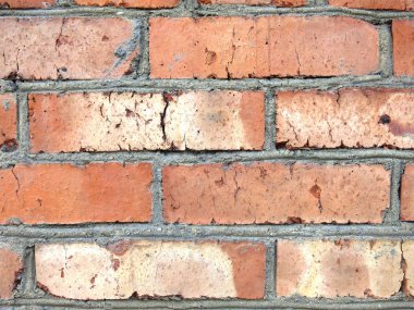 Kırmızı tuğla duvarın dokusu çimento katmanıyla kaplıdır.    