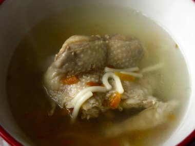 Tavuklu erişte, bir parça tavuk ve havuç kasede.    