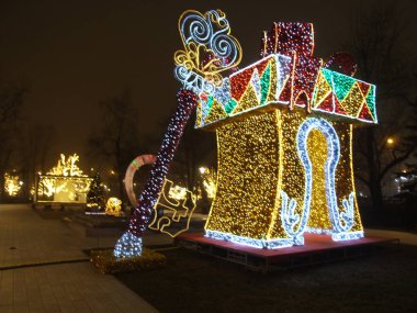 Caddedeki parkta, üzerinde anahtar olan bir hediye kutusu şeklinde parlayan büyük bir Noel figürü.