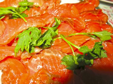 Kırmızı alabalık, yeşil bir tabakta dilimlenmiş.