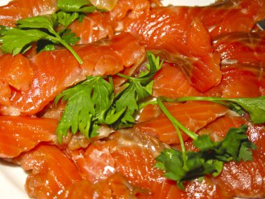 Kırmızı alabalık, yeşil bir tabakta dilimlenmiş.