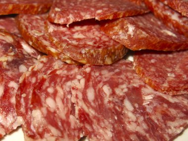 Bir tabakta domuz yağıyla dilimlenmiş sosisli salam.