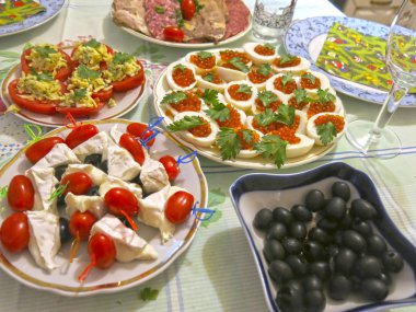 Festival masası seti: dilimlenmiş et, kanepe, peynir, zeytin, yumurta içinde havyar, peynirli domates ve sarımsak.