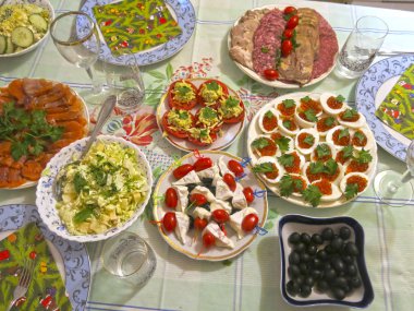Festival masası seti: dilimlenmiş et, kanepe, peynir, zeytin, yumurta içinde havyar, peynirli domates ve sarımsak.