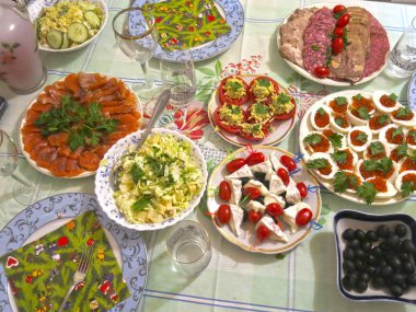 Festival masası seti: dilimlenmiş et, kanepe, peynir, zeytin, yumurta içinde havyar, peynirli domates ve sarımsak.