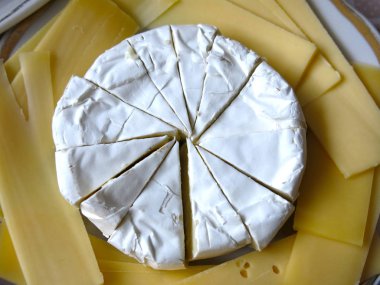 Beyaz Camembert peyniri ve sarı sert peynir yaprakları.  