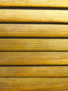 background of yellow wooden horizontal slats in sunlight