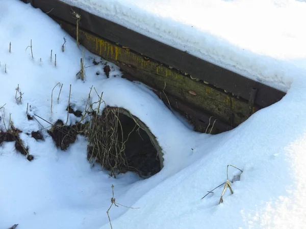 wide pipe under the bridge under the snow
