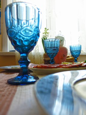 Atıştırmalıklarla ve ağır mavi cam bardaklarla kaplı festival masası.