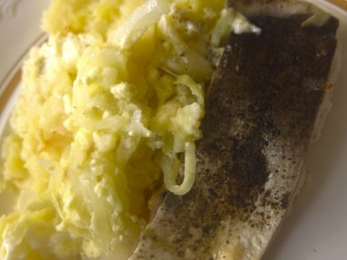 Tabakta patates ve soğanlı fırında balık.