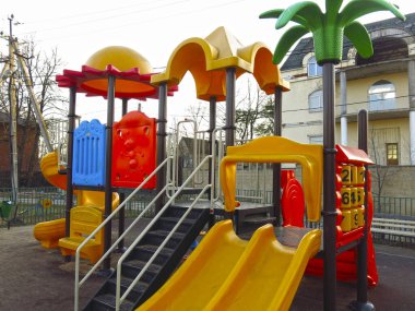 Açık havada slayt ve merdivenleri olan parlak plastik elementlerden oluşan oyun alanı