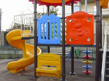 Açık havada slayt ve merdivenleri olan parlak plastik elementlerden oluşan oyun alanı