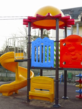 Açık havada slayt ve merdivenleri olan parlak plastik elementlerden oluşan oyun alanı