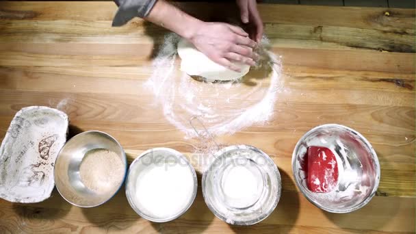 Мужские руки готовят тесто для хлеба на столе - вид сверху — стоковое видео