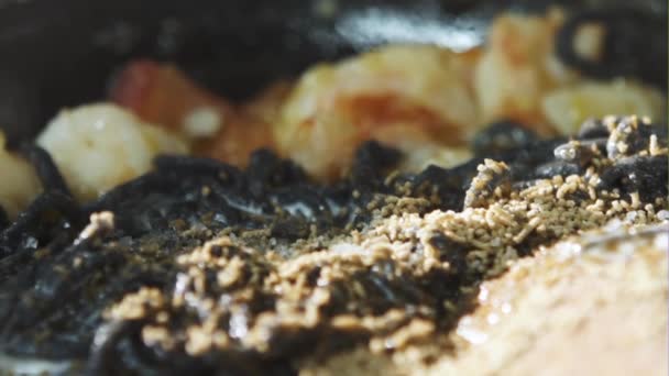 Черный кальмар чернил макароны с морепродуктами в кастрюле — стоковое видео