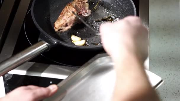 Человек готовит бифштекс на сковородке. — стоковое видео