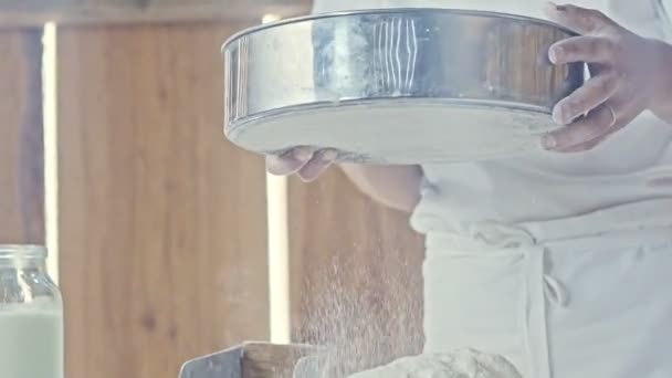 Cook sifting flour through a metal sieve — Stock Video