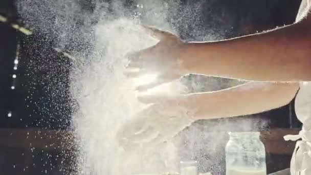 Young chef clapping his hands filled with flour — Stockvideo