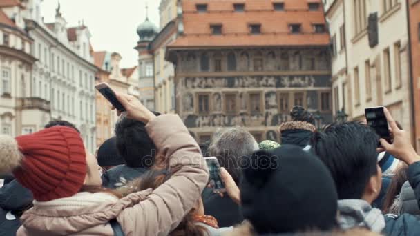 Prague, Tsjechië - 24 December 2016: vol oude stadsplein, populaire toeristische bestemming. Mensen die foto's van lokale landmark astronomische klok. — Stockvideo