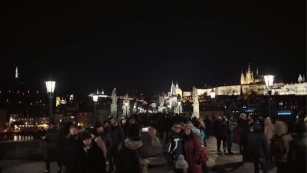 Praga, República Checa - 24 de diciembre de 2016: Una multitud de turistas en el Puente de Carlos por la noche . — Vídeo de stock