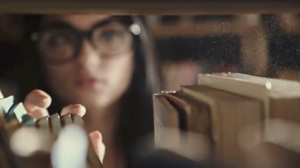 Mujer buscando libros en una biblioteca — Vídeos de Stock