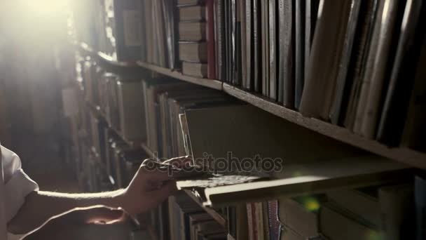 Девушка в библиотеке сдула пыль со старого квартала документа — стоковое видео