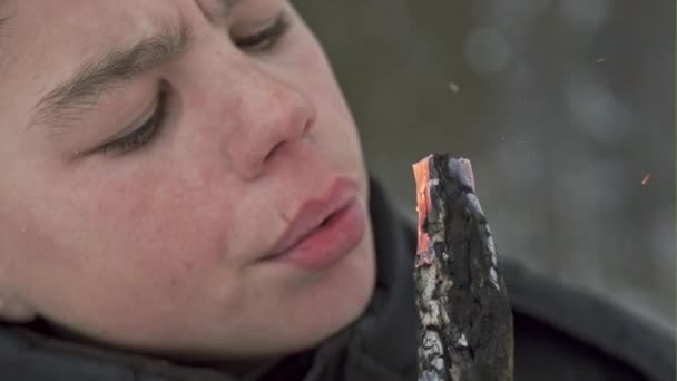 Povero bambino mendicante che si scalda al personale ardente che lo gonfia sullo sfondo del freddo inverno nella foresta — Video Stock