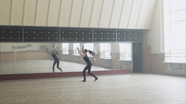 Vacker ballerina poserar framför spegeln i dance studio — Stockvideo