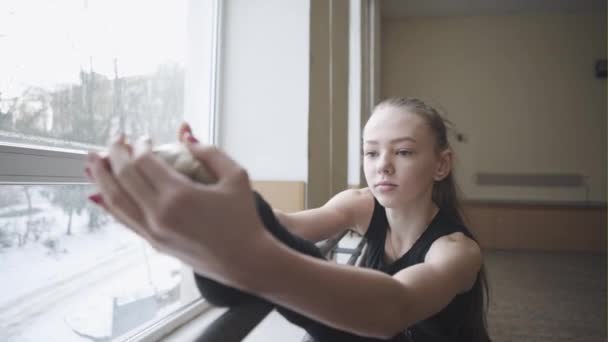 Close-up, meisje in zwarte leotard stretch op ballet klas spieren uit te rekken op de barre stand — Stockvideo